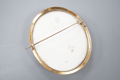 A yellow metal mounted porcelain miniature oval brooch, painted with a young boy, 64mm, gross weight 25.1 grams.